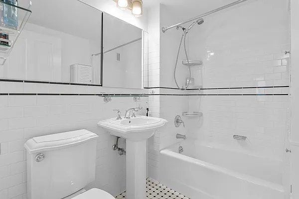 bathroom featuring toilet, shower / tub combination, and a sink