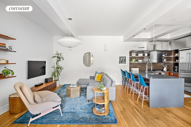 living room with sink and light wood-type flooring