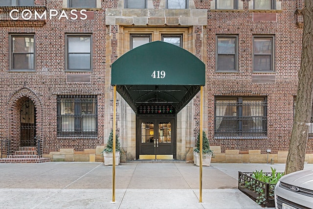 property entrance featuring french doors and brick siding