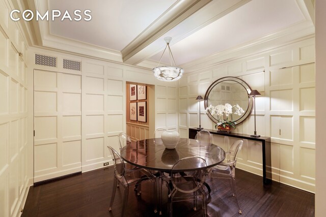 dining room featuring ornamental molding, dark wood-style flooring, and a decorative wall