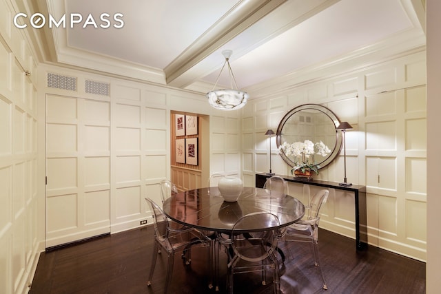 dining area with crown molding, dark wood-style flooring, and a decorative wall