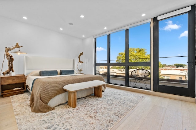 bedroom with light wood-style floors, recessed lighting, and floor to ceiling windows