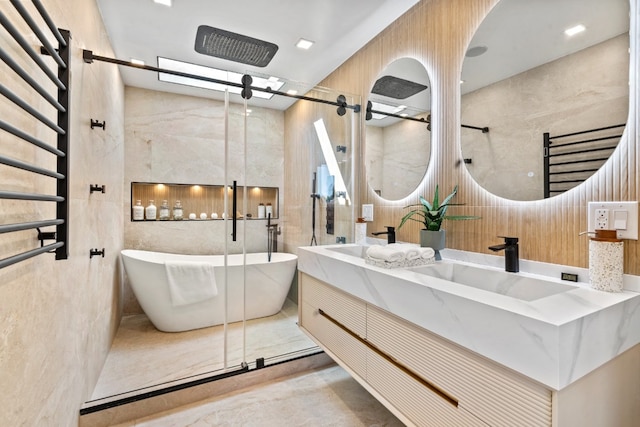 bathroom with tile walls, double vanity, a soaking tub, radiator heating unit, and a sink