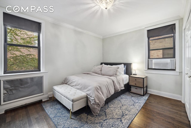 bedroom with radiator, crown molding, baseboards, and wood finished floors