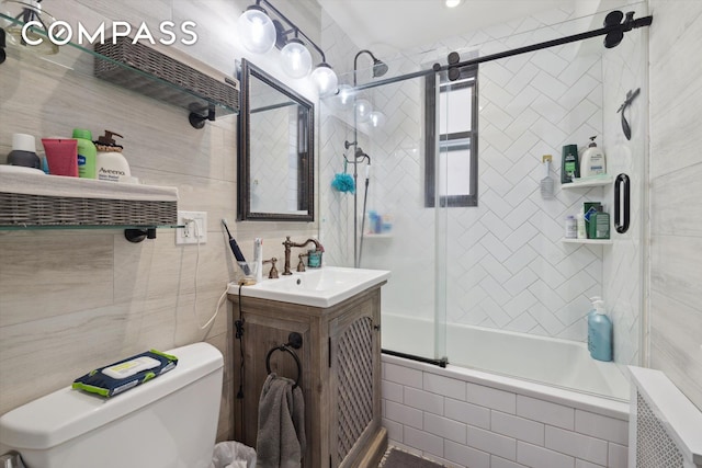 221 E 78th St Unit 4J, New York City, NY 10075 - bathroom with tiled shower / bath, toilet, tile walls, and vanity