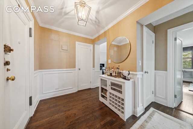 221 E 78th St Unit 4J, New York City, NY 10075 - entrance foyer with a decorative wall, dark wood-type flooring, wainscoting, a chandelier, and crown molding