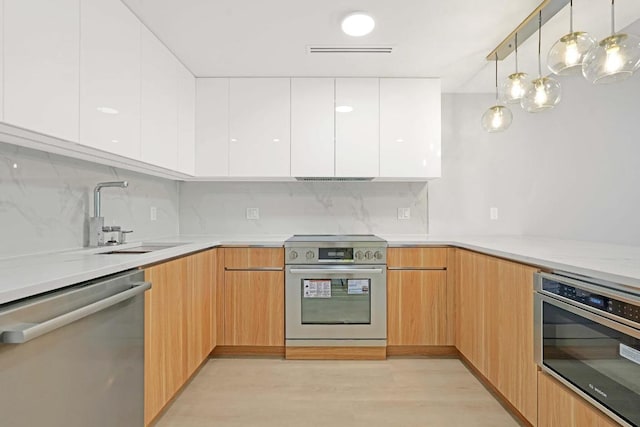 kitchen featuring sink, tasteful backsplash, decorative light fixtures, stainless steel appliances, and white cabinets