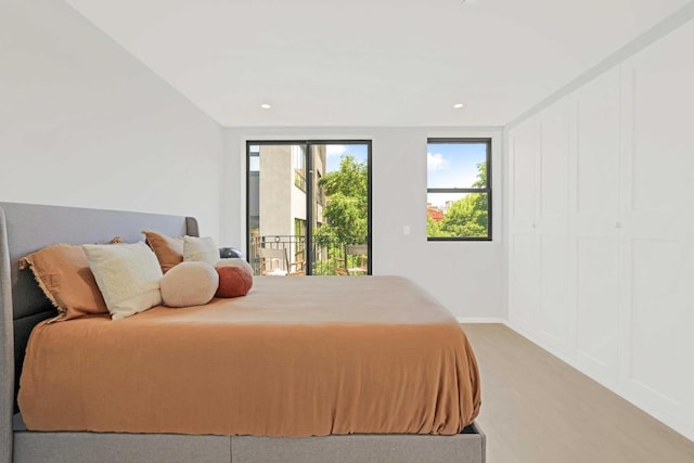 bedroom with access to exterior and light hardwood / wood-style flooring