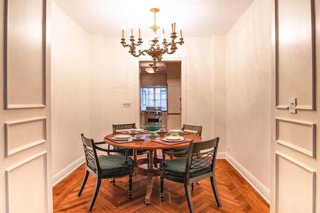 dining area with baseboards and a chandelier