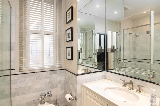 bathroom with tile walls, a shower with door, a bidet, and vanity