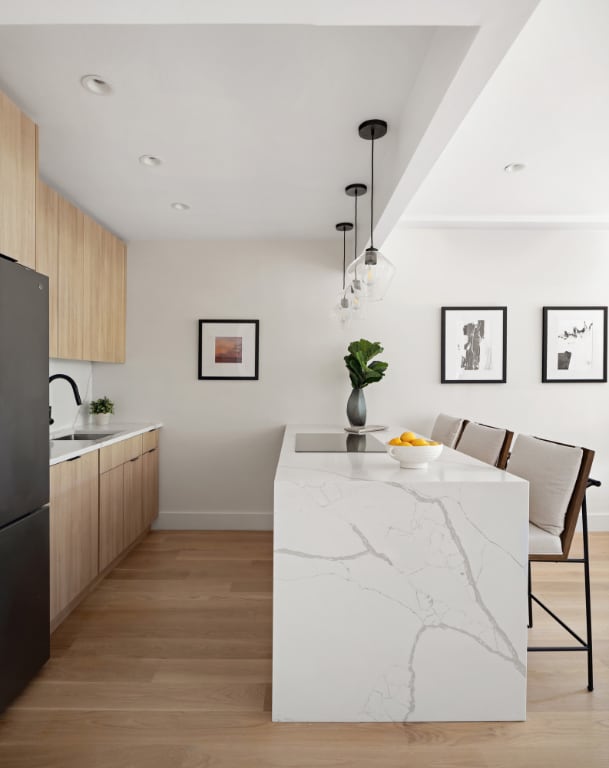 kitchen with refrigerator, sink, light wood-type flooring, and decorative light fixtures