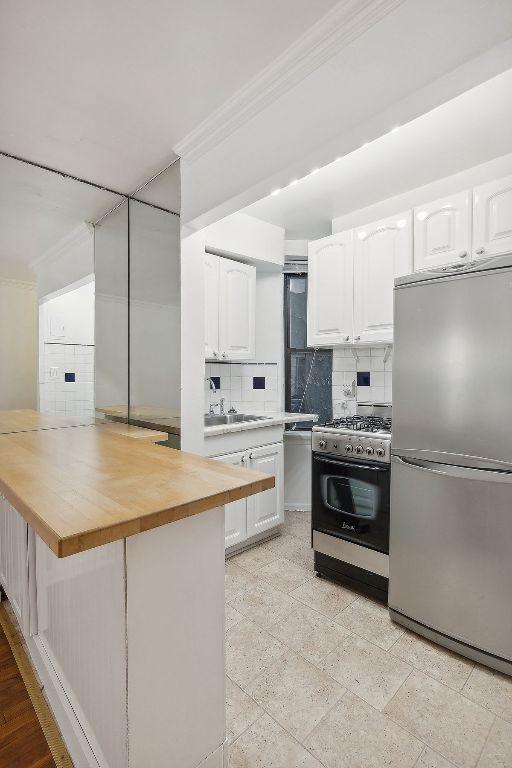 kitchen featuring white cabinetry, stainless steel appliances, and kitchen peninsula