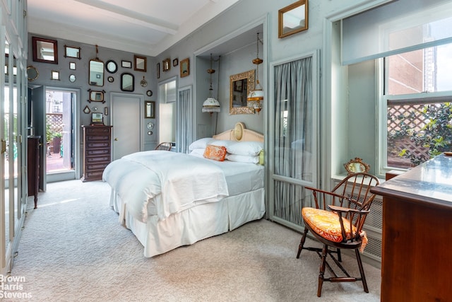 carpeted bedroom with beam ceiling