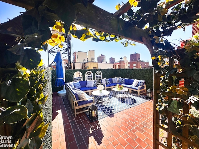 view of patio featuring an outdoor living space, a view of city, and fence