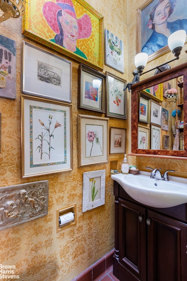 bathroom with wallpapered walls and vanity