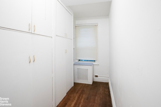 corridor with baseboards and wood finished floors