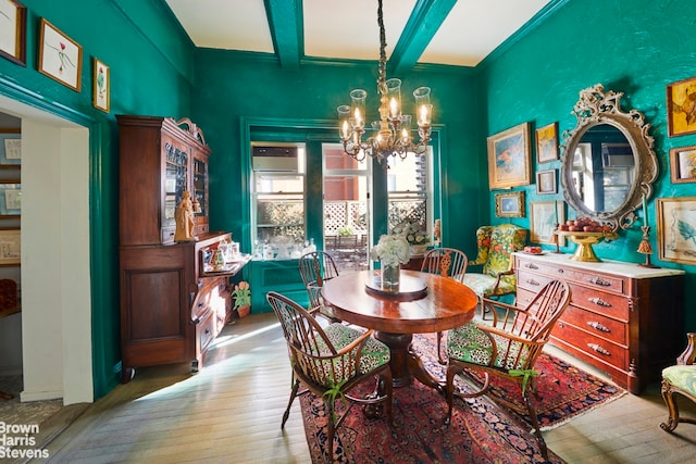 dining room featuring beam ceiling, a chandelier, and light hardwood / wood-style floors