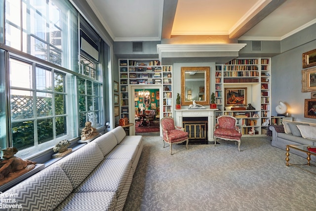 sitting room featuring visible vents, carpet floors, beam ceiling, a fireplace with flush hearth, and crown molding