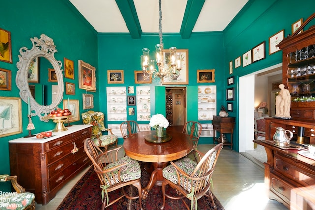 dining space with beamed ceiling, an inviting chandelier, and wood finished floors