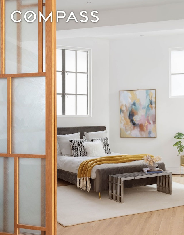 bedroom featuring multiple windows and wood finished floors