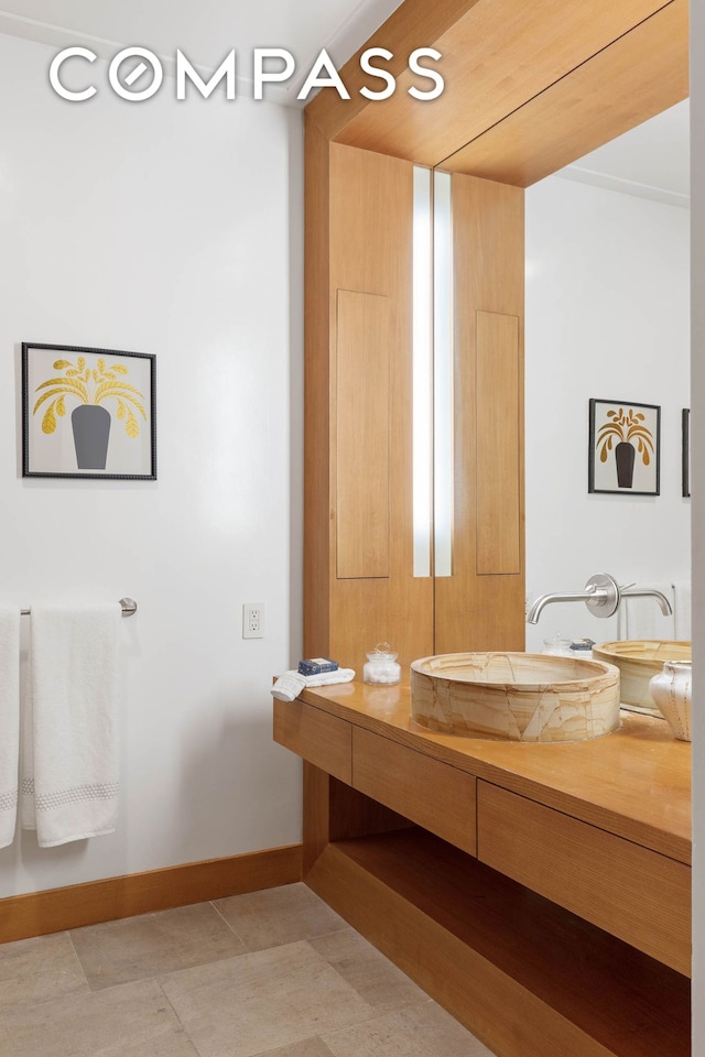 bathroom featuring vanity, tile patterned floors, and baseboards