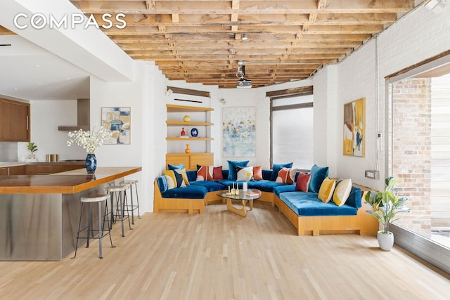 living area featuring wood finished floors and brick wall