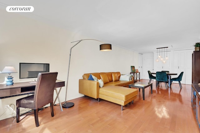 living area featuring light wood finished floors, visible vents, and a chandelier