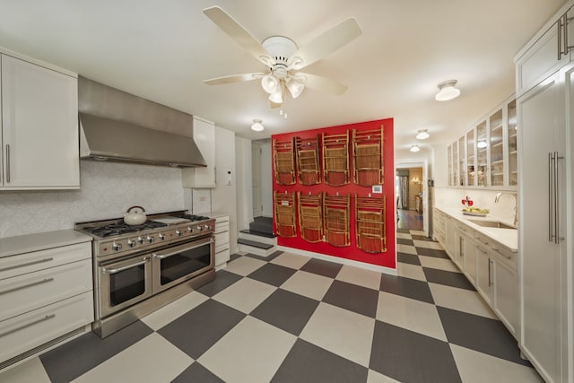 6 Sutton Sq, New York City, NY 10022 - kitchen with double oven range, wall chimney exhaust hood, ceiling fan, tile patterned floors, and light countertops