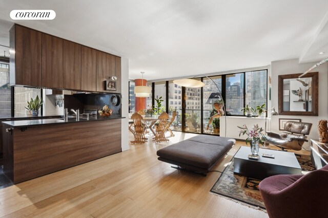 living room featuring a wall of windows and light wood-type flooring