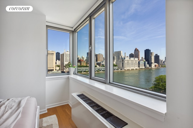 living area with a view of city, visible vents, baseboards, and wood finished floors