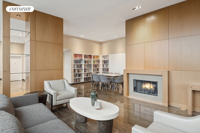 living area with wood finished floors, a glass covered fireplace, and visible vents