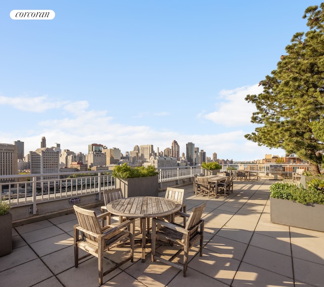 view of patio with outdoor dining space and a city view