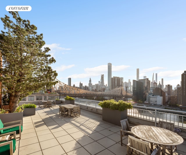 view of patio with outdoor dining space, a city view, and a water view