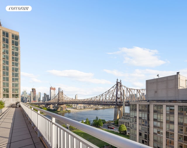 balcony featuring a water view and a city view