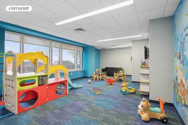 game room featuring a paneled ceiling, carpet, visible vents, and baseboards