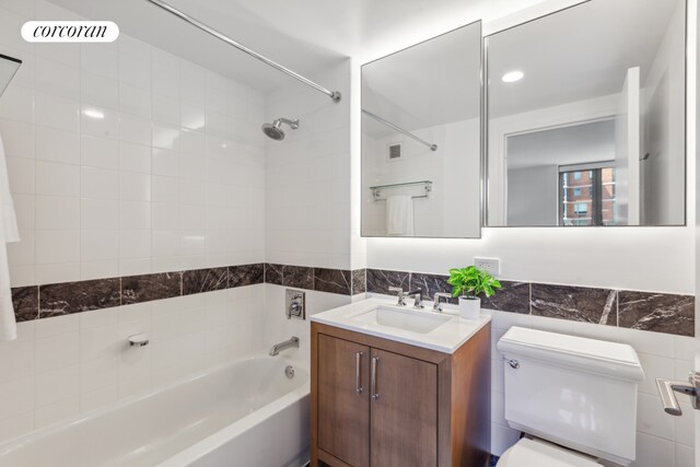 425 Main St Unit 12D, New York City, NY 10044 - full bathroom featuring visible vents, vanity, toilet, tile walls, and shower / tub combination