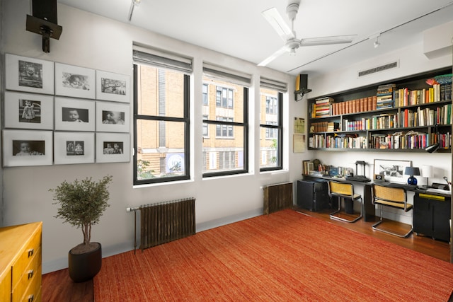 home office with hardwood / wood-style flooring, rail lighting, radiator heating unit, and ceiling fan