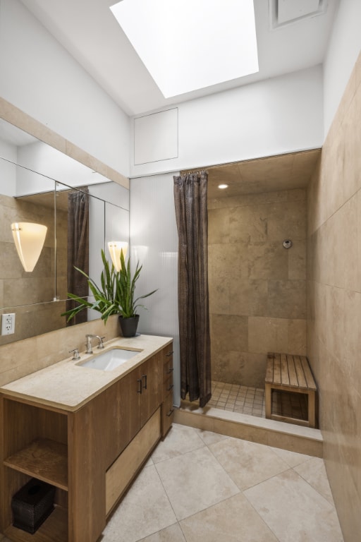 bathroom featuring vanity, tile patterned flooring, a skylight, and a shower with shower curtain