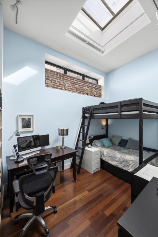 bedroom featuring dark wood-type flooring and a skylight