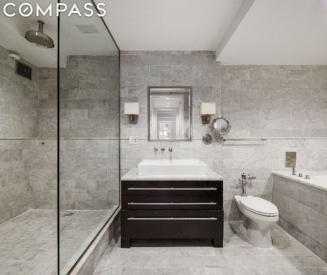 bathroom featuring walk in shower, toilet, tile walls, vanity, and tile patterned flooring