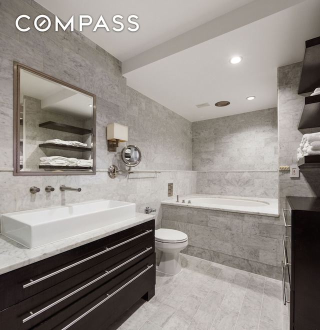 bathroom featuring toilet, recessed lighting, tile walls, a bath, and vanity