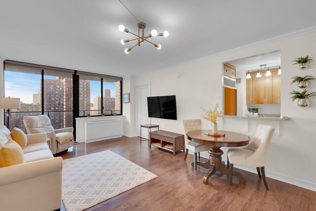 living room with a healthy amount of sunlight, a chandelier, dark wood-style flooring, and crown molding