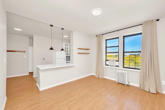 unfurnished living room with light wood-type flooring and radiator heating unit