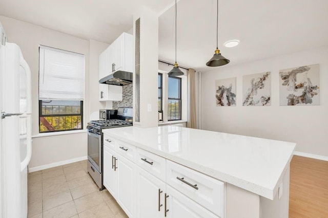 kitchen with decorative light fixtures, stainless steel range with gas cooktop, white cabinetry, and white refrigerator