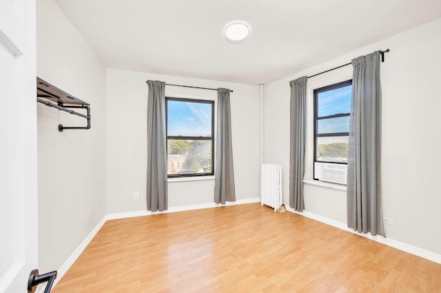 empty room with radiator and wood-type flooring