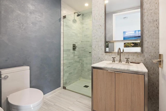 bathroom featuring an enclosed shower, vanity, and toilet