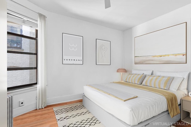 bedroom with ceiling fan and light hardwood / wood-style flooring