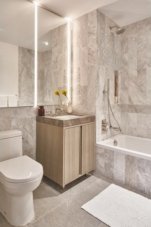 full bathroom featuring tile walls, tile patterned flooring, tiled shower / bath combo, vanity, and toilet