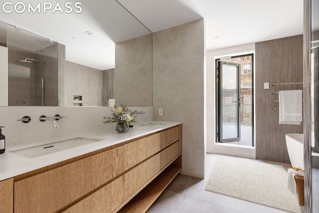 bathroom featuring shower with separate bathtub, tile patterned floors, vanity, and tile walls