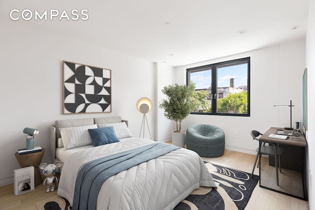 bedroom featuring baseboards and wood finished floors